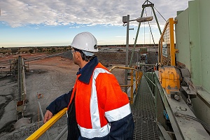 concrete crusher worker looking over quarry from a rock crushing platform