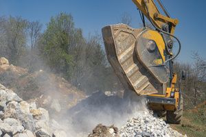An excavator vehicle offloading crushed stones