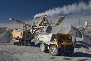 Huge rock crushers, trucks, and excavator vehicles