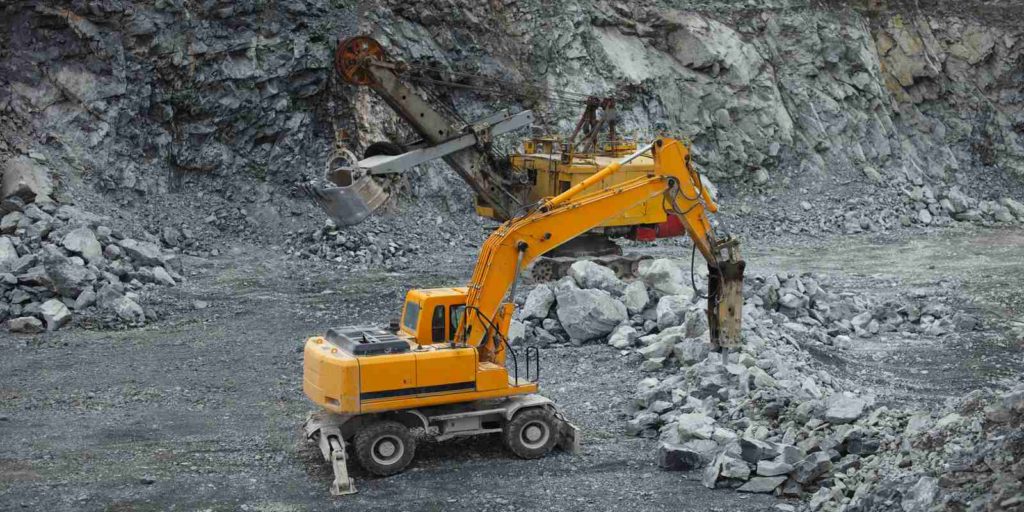 Hydraulic hammer and mining excavator in the rock quarry