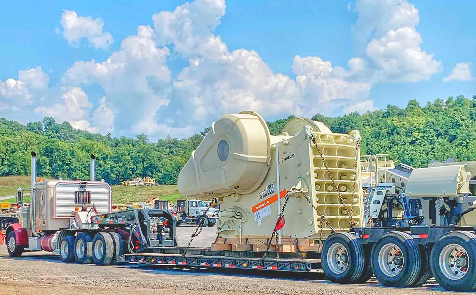 large stone crushing machine being hauled to a job site